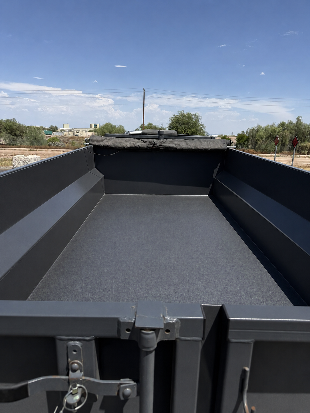 Open black dump trailer showing the space inside